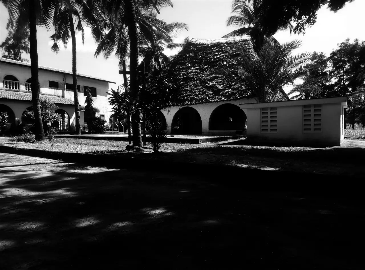 Black Groove Lounge in Kiwandani Green Estate, Kilifi — the makuti-thatched main house with its arched veranda, the guest wing and coconut palms